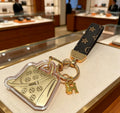 Hermès Gold-Tone Handbag-Charm Keychain with Black Strap - album image 1