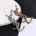 Saint Laurent Silver and Gold-Tone Twisted Monogram Brooch - album image 1